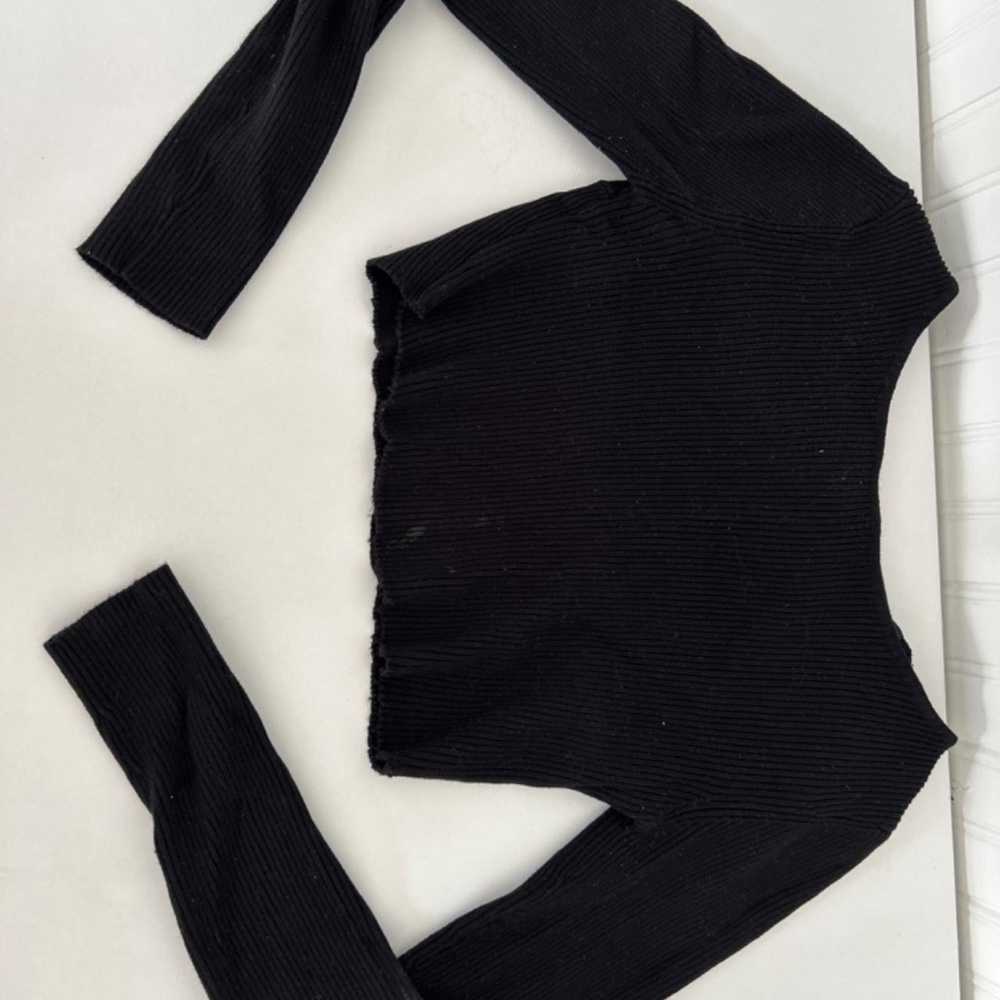 long-sleeved black top, open back with bow.
